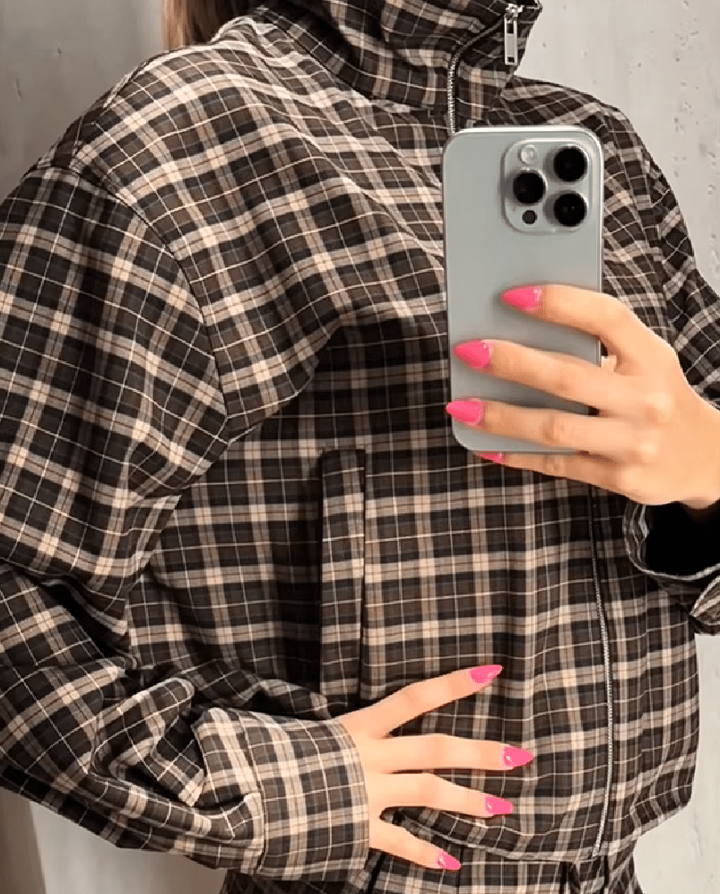 Růžový kabát s vysokým límcem a kostkovaným vzorem na zip
